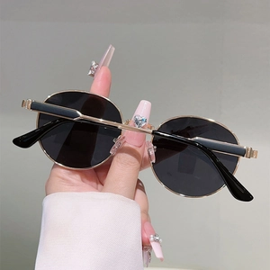 Detailed close-up of retro round gold metal frame sunglasses with classic black lenses