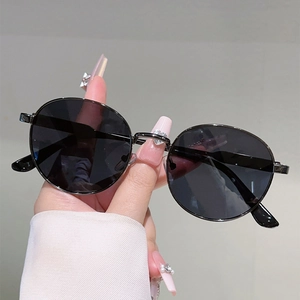 Detailed close-up of premium black round lens sunglasses with minimalist metal frame
