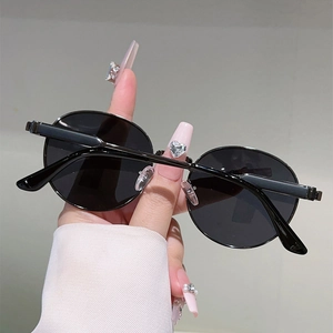 Close-up of retro round black sunglasses with slim metal frames and adjustable nose pads