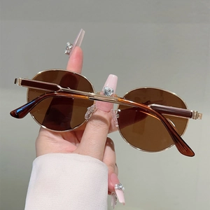 Close-up of amber lenses with gold metal frame and heart crystal detail on bridge