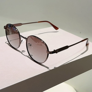 Detail of vintage round metal sunglasses with gradient lenses and tortoiseshell temple tips