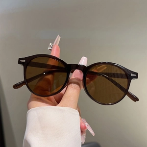 Close-up of retro round brown sunglasses with polished frame and metallic rivet detail