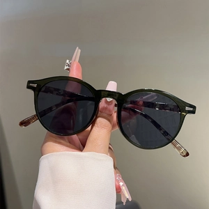 Close-up of vintage round frame sunglasses with dark lenses and silver metal accents
