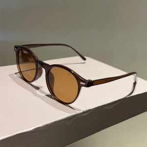 Detail of round frame sunglasses showing brown translucent material and metal studs