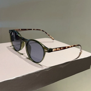 Fashionable round green sunglasses with tortoiseshell temples and grey polarized lenses