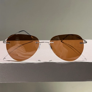 Vue frontale de lunettes aviateur sans monture avec verres bruns et cadre argent