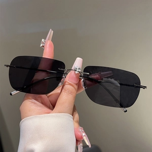 Detail of rimless polarized sunglasses with silver metal temples and square dark lenses