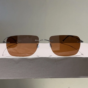 Close-up of rimless brown rectangular sunglasses with silver metal temples and frame