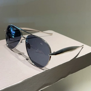 Detail of silver aviator sunglasses with polarized lenses on a textured display stand