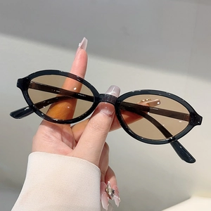 Détail de lunettes de soleil ovales rétro noires avec verres marrons