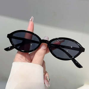 Détail de lunettes de soleil ovales vintage avec monture en résine noire lisse