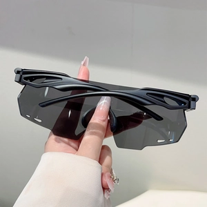 Detail of black sporty oversized sunglasses featuring futuristic hollowed-out side temples