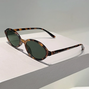 Gros plan de lunettes de soleil ovales rétro avec monture écaille et verres vert foncé