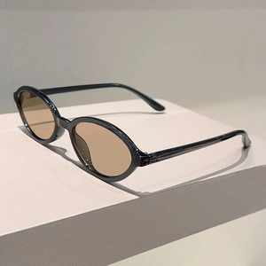 Détail de lunettes de soleil ovales léopard avec verres bruns sur un socle minimaliste