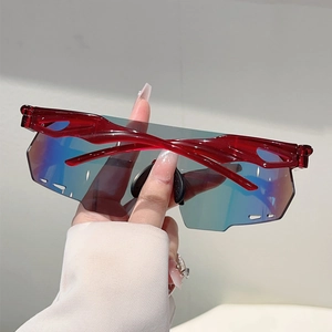 Detail of red oversized sports sunglasses with blue mirrored lens and wavy frame