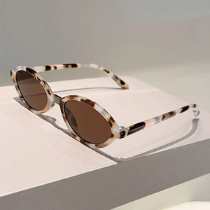 Détail de lunettes de soleil ovales en écaille avec verres bruns sur présentoir moderne