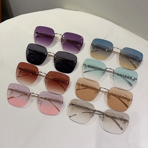 Détail de lunettes de soleil carrées sans monture avec verres dégradés et perles
