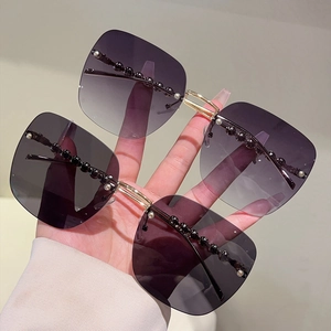 Détail de lunettes de soleil carrées sans monture avec dégradé et perles sur le bord