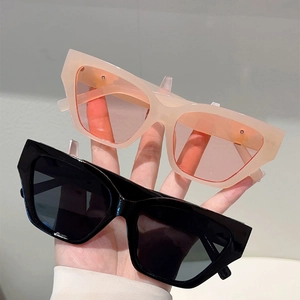 Detail of hand-held cat-eye sunglasses in nude pink and classic black chunky frames