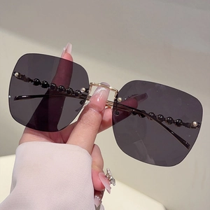 Détail de lunettes de soleil carrées sans monture avec perles décoratives de luxe
