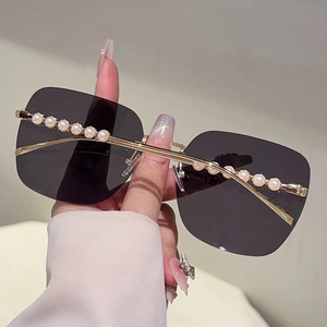 Détail de lunettes de soleil carrées sans monture avec perles et verres dégradés gris