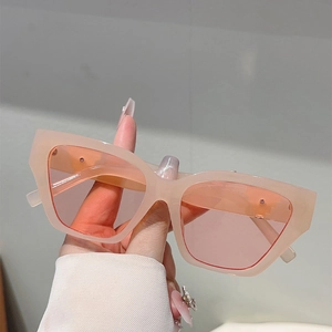 Close-up of pink cat eye sunglasses with translucent frames and oversized polygon design