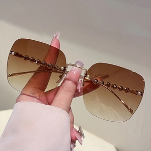 Détails de lunettes de soleil carrées sans monture avec verres dégradés et branches perlées