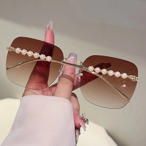 Détail de lunettes de soleil carrées sans monture avec dégradé brun et perles de luxe