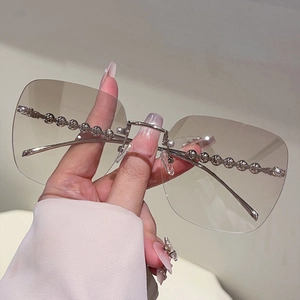Vue détaillée des lunettes de soleil carrées sans monture avec verres dégradés et perles