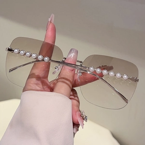 Détail de lunettes de soleil carrées sans monture avec perles élégantes incrustées