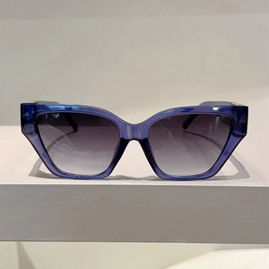 Detail showing translucent blue geometric frame and grey gradient lenses of the sunglasses