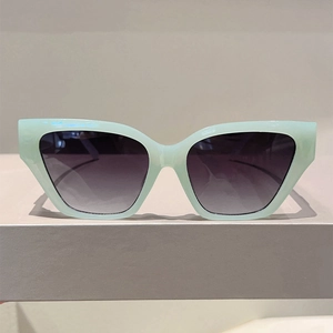 Detail of oversized cat-eye sunglasses with mint green frames and gradient lenses