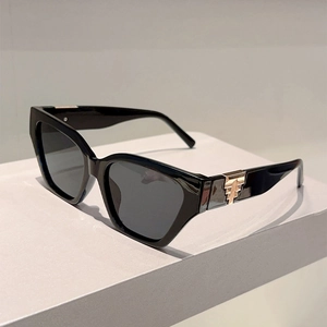 Detailed side view of oversized black sunglasses featuring elegant gold geometric temple decor