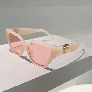 Detail of light pink cat-eye sunglasses featuring elegant gold metal temple accents