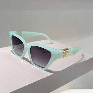 Detail of mint green cat-eye frame with gold metal hinge and gradient purple lenses
