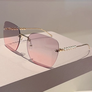 Détail de lunettes de soleil carrées sans monture avec verres dégradés et perles dorées