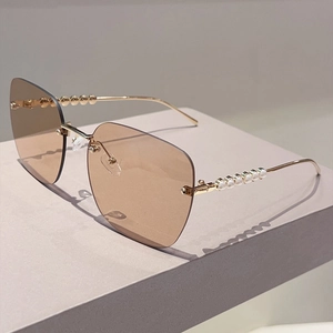Détail de lunettes de soleil carrées sans monture avec perles sur branches dorées