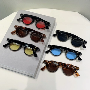 Detail view of flip-up round sunglasses with metal rivet accents and various lens colors