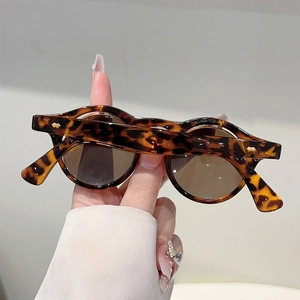 Detail of round tea lenses and tortoise shell frame with metal rivet accents