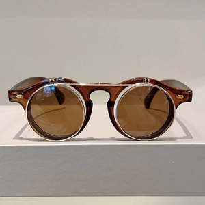 Close-up of retro flip-up sunglasses with tortoiseshell round frames and gold rivet details