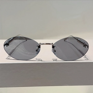 Fashionable rimless oval sunglasses with dark grey lenses and decorative pearl details
