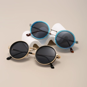 Detail of retro round sunglasses with gold and silver frames on a wave display stand
