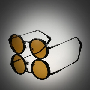 Macro detail of round metal sunglasses with amber lenses and black steampunk frame