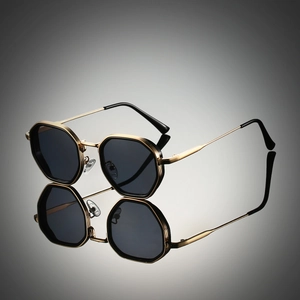 Steampunk polygonal metal sunglasses with gold frame and dark lenses on a reflective surface
