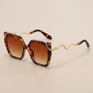 Macro view showing golden snake-shaped metal temples on tortoiseshell square sunglasses