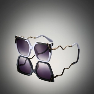 Close-up of golden snake-shaped metal temples on stylish oversized sunglasses with gradient lenses