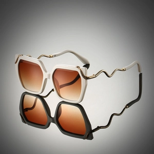 Detail of gold snake-shaped metal temples on white hexagonal gradient sunglasses