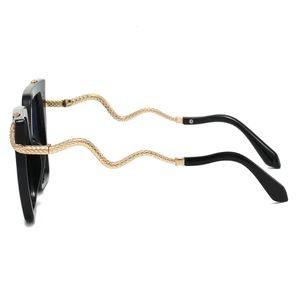 Detail of vintage sunglasses featuring golden snake-patterned temples on black frames