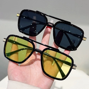 Close-up of double-bridge oversized sunglasses with black and yellow lenses and metal accents