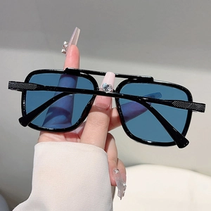 Detail of blue tinted lenses and double bridge design on large frame black sunglasses